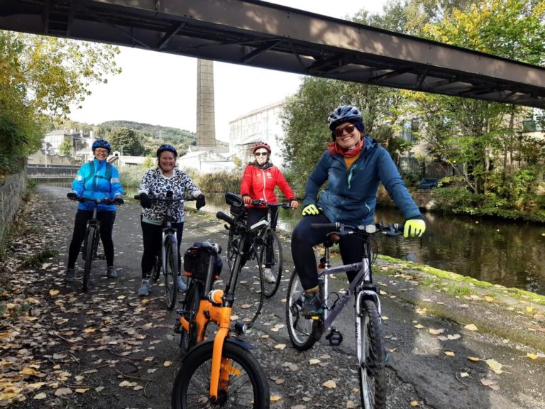 Four women on bikes on towpath.