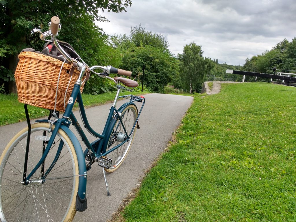 Teal bike with basket on a towpath.