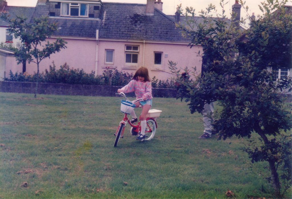 Girl on bike in field.
