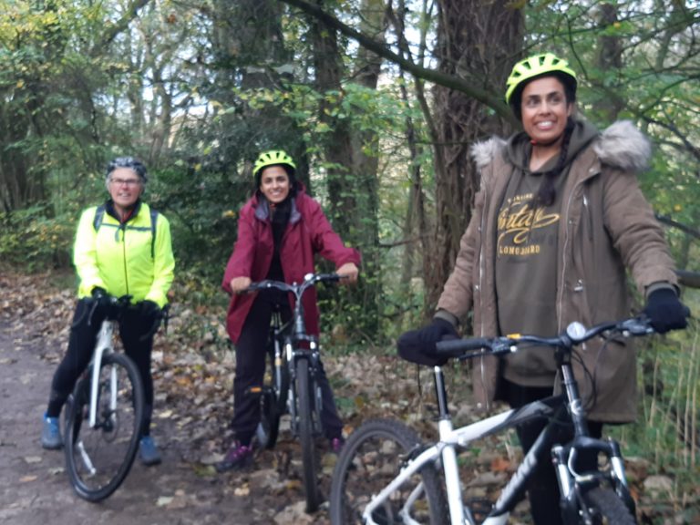 Three women on bikes on the towpath.