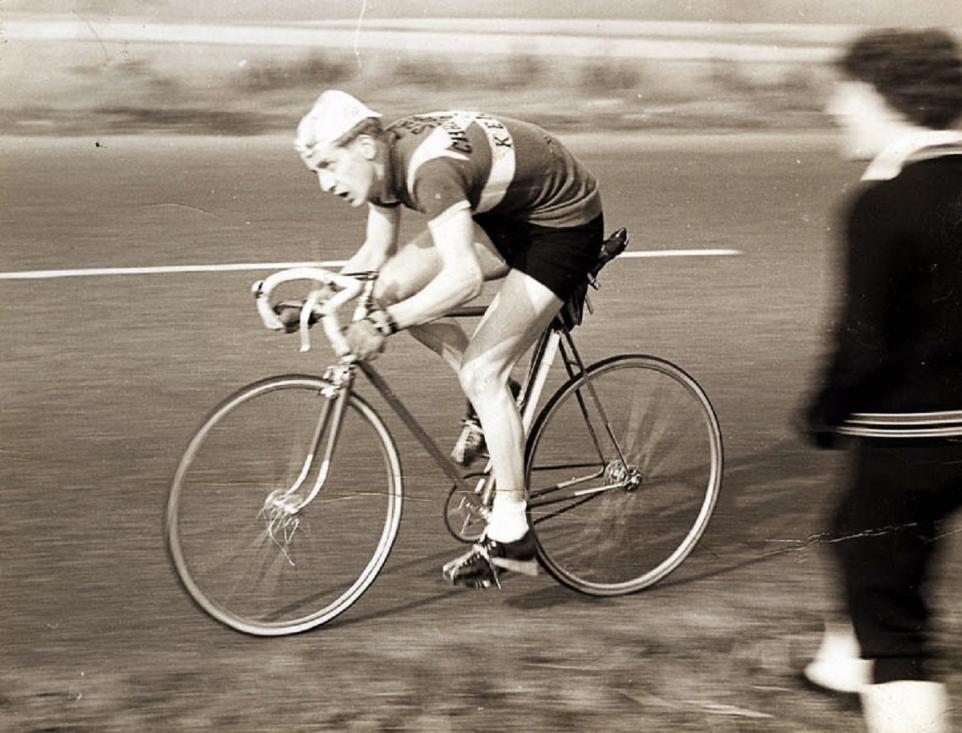 Black and white picture of man on road bike.