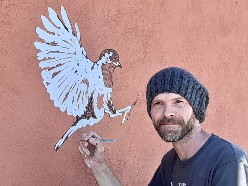 Artist working on a wall painting