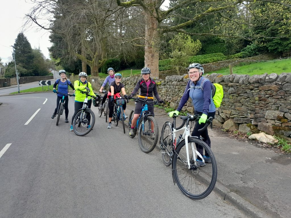 A group of women taking a break before continuing their cycle ride up the hill