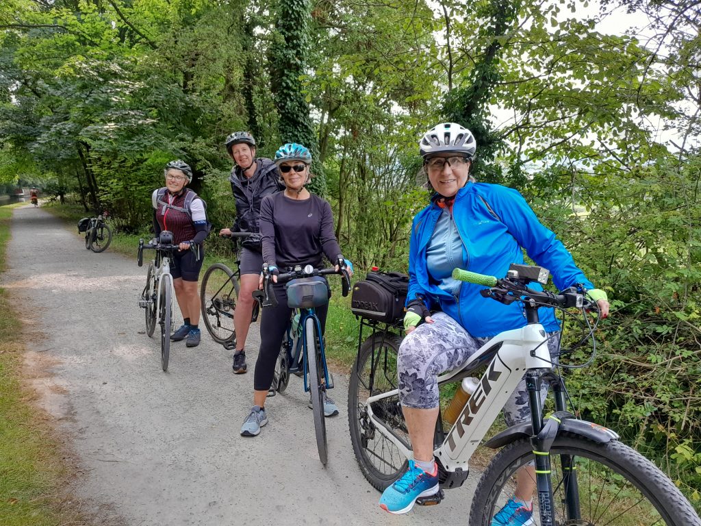 Group of women cyclists halted for a photo on the towpath