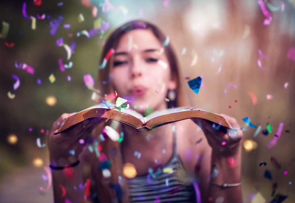 woman blowing confetti from a book