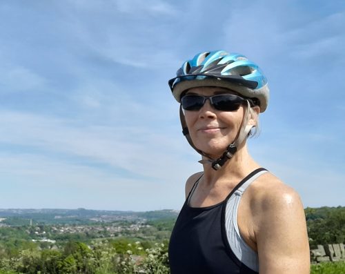 Smiling woman cyclist in the sunny countryside