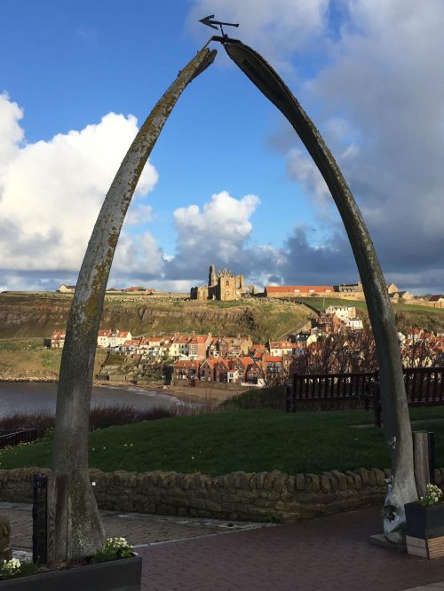 A picture looking through the Whale Bone sculpture across the bay to Whitby Abbey