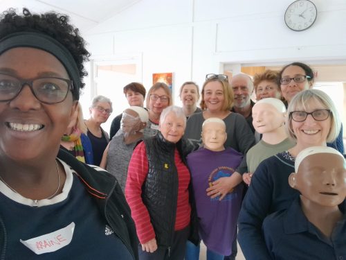 Group of student first aiders with instructor and manekins