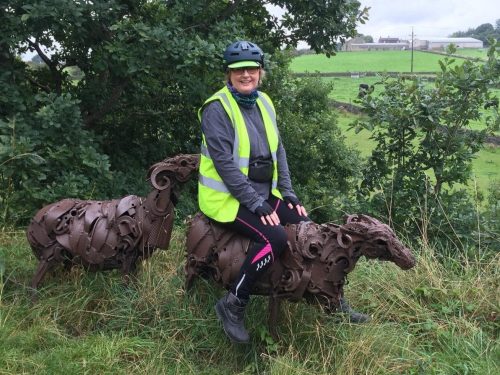 Lady in cycling kit astride a cast iron sheep