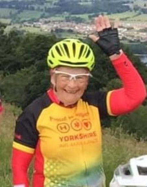 Woman in yellow helmet and Yorkshire Air Ambulance cycling jersey.