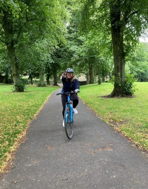 Woman on bike in park.