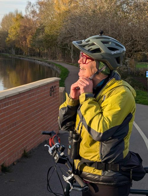 Woman cyclist adjusting helmet outside RNR
