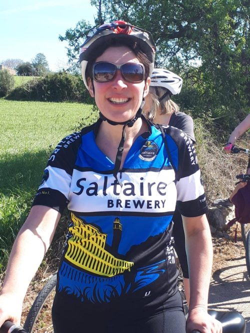 Woman in Saltaire Brewery cycling jersey and sunglasses.